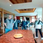 Dee Norlin, right, of Port Townsend and host at Pasture House, one of the eight homes on the AAUW Kitchen Tour on Marrowstone Island, points out the cabinetry, red alder, madrona and cedar and counter surfaces in a recently remodeled home and kitchen using the latest technologies to make the home eco-friendly and efficient. (Steve Mullensky/for Peninsula Daily News)
