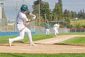 Port Angeles' Brandt Perry swings at a pitch at Civic Field while teammate Josiah Gooding takes a lead off third base. The Riders beat Bremerton 9-0 to remain in third place in the Olympic League. (Pierre LaBossiere/Peninsula Daily News)