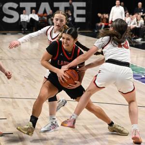 Jesse Tinsley/ The Spokesman-Review
Neah Bays Qwaapeys Greene forces her way through Garfield-Palouse defenders in the Class 1B girls championship game at the Spokane Arena on March 8. The Red Devils beat the Vikings 36-46 in the B Tournament finale to cap their third straight state championship victory.