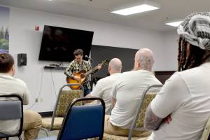 Matt Butler performs for about 70 incarcerated people in the visiting room at Clallam Bay Corrections Center on Thursday afternoon. (Elijah Sussman/Peninsula Daily News)