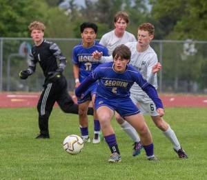 Sequim's Finn Braaten (5) and Evan Cisneros (17) battle for the ball against Port Angeles' Sawyer Davis (6). Port Angeles goalkeeper Gus Halberg (1) is also in on the play. Sequim won the crucial game 1-0 Friday in Sequim. (Emily Mathiessen/Olympic Peninsula News Group)