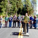 Gov. Bob Ferguson addresses the crowd at the Upper Hoh Road washout repair on Thursday afternoon. Local officials, business owners, contractors, workers from the Jefferson County Public Works department and a few individuals who donated funds to the project stand behind him. Before the ribbon was cut and the road officially opened, there were short statements from involved parties. Ferguson said he brought his hiking boots and joked that he wanted to be the first one to hit the trail. (Christi Baron/Olympic Peninsula News Group)