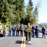 Gov. Bob Ferguson addresses the crowd at the Upper Hoh Road washout repair on Thursday afternoon. Local officials, business owners, contractors, workers from the Jefferson County Public Works department and a few individuals who donated funds to the project stand behind him. Before the ribbon was cut and the road officially opened, there were short statements from involved parties. Ferguson said he brought his hiking boots and joked that he wanted to be the first one to hit the trail. (Christi Baron/Olympic Peninsula News Group)