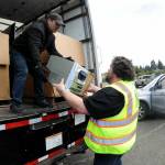 Olympic Kiwanis Club member Tobin Standley, right, hands a piece of stereo equipment to Gerald Casasola for disposal during Saturdays electronics recycling collection day in the parking lot at Port Angeles Civic Field. Items collected during the roundup were to be given to Friendly Earth International Recycling for repairs and eventual resale, or else disassembled for parts. Club members were accepting monetary donations during the event as a benefit for Kiwanis community programs. (Keith Thorpe/Peninsula Daily News)