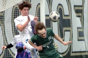 KEITH THORPE/PENINSULA DAILY NEWS
Port Angeles' Grant Butterworth, front, tries to steer an incoming corner kick as Olympic's Jackson Wyall and goalkeeper Mariano Pena defend the net during Saturday's playoff game at Peninsula College.