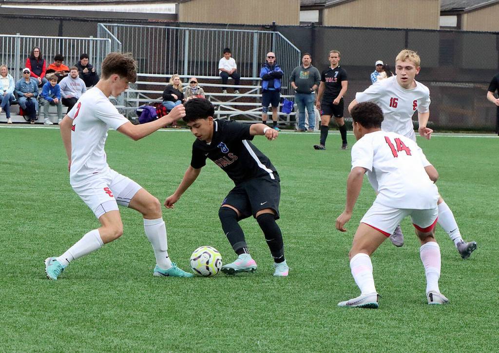The East Jefferson Rivals met the Seattle Christian soccer team in a District 3 1A playoff match Saturday at Peninsula College. Here, East Jeffersons Alan Morales (8) tries to control the ball against Seattle Christian defenders. (Dave Logan/for Peninsula Daily News)