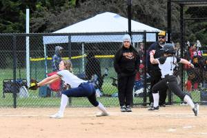 Forks Avery Diley takes the throw at first for the out against Rainier runner Mia Naval on Wednesday afternoon at Borst Park in Centralia during the District 4 tournament. The Spartans fell to the Mountaineers 8-7 to close out the season. (Lonnie Archibald/for Peninsula Daily News)