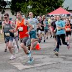 The Rhody Runs womens 10K winner, Fiona Fraser, (1131) is on the heels of her father, Ian (1132), who finished fourth among the men, as they exit the Jefferson County Fairgrounds at the start of the 44th annual Jefferson Healthcare Rhody Run on Sunday. (Steve Mullensky/for Peninsula Daily News)