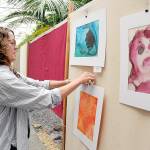 Kayla Oakes, former director of the Juan de Fuca Festival Foundation and current director of education for Field Arts & Events Hall, hangs student artwork in the Port Angeles City Hall atrium on Thursday in preparation for this weekends Juan de Fuca Festival of the Arts. The three-day festival features music, food, a craft market and other entertainment spread over four stages. Additional festival information is available at jffa.org. (Keith Thorpe/Peninsula Daily News)