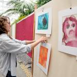 Kayla Oakes, former director of the Juan de Fuca Festival Foundation and current director of education for Field Arts & Events Hall, hangs student artwork in the Port Angeles City Hall atrium on Thursday in preparation for this weekends Juan de Fuca Festival of the Arts. The three-day festival features music, food, a craft market and other entertainment spread over four stages. Additional festival information is available at jffa.org. (Keith Thorpe/Peninsula Daily News)