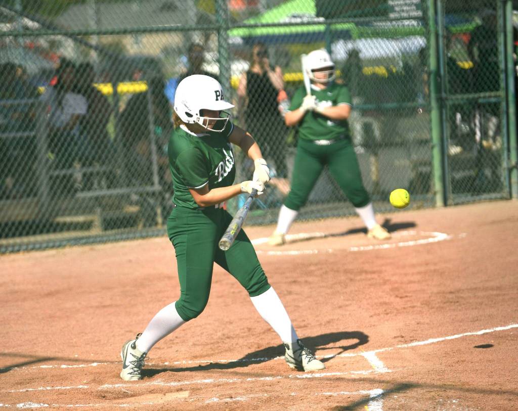Port Angeles Kennedy Rognlien swings at a pitch Friday in Selah against Woodland as teammate Abby Kimball waits in the on-deck circle. (Dan Rosenfield/Longview Daily News)