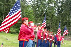 Kelsey Macias, left, a U.S. Marine veteran, played taps on her bugle on Monday at Mount Angeles Cemetery. At the conclusion of the Memorial Day Service, a three-gun salute was fired by a veteran honor guard. (Dave Logan/for Peninsula Daily News)