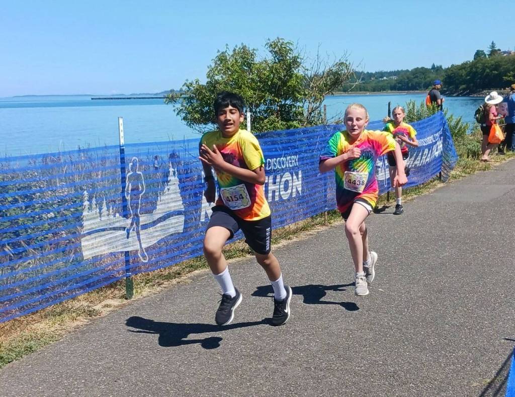 Two young runners in the kids marathon sprint to the finish Saturday afternoon at the Port Angeles City Pier. (Pierre LaBossiere/Peninsula Daily News)