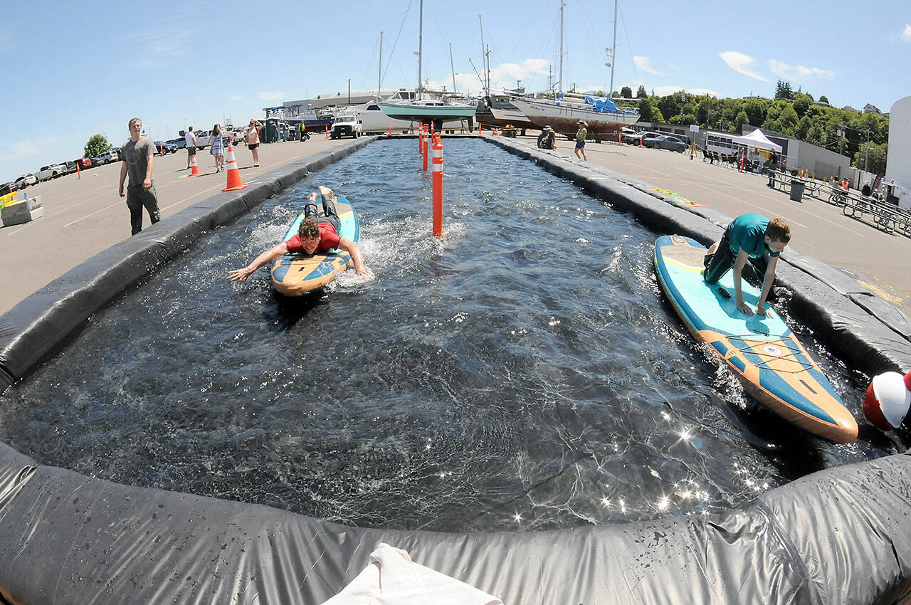 Ethan Davidson, 16, left, competes with his brother, Pierce Davidson, 12, both of Dallas, Texas, in a paddleboard race on a temporary course set up at East Boat Haven in Port Angeles as part of the weekends Maritime Career Fair & Festival. The two-day event, hosted by the Port of Port Angeles, featured informational displays, childrens activities, maritime demonstrations, food, music and a fishing derby. (Keith Thorpe/Peninsula Daily News)
