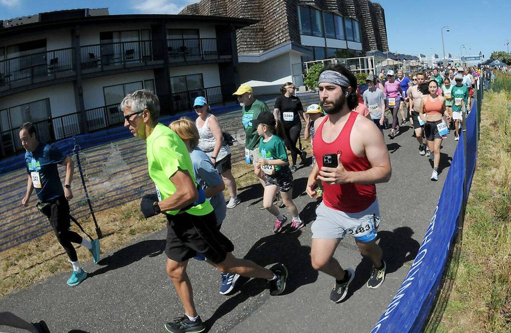 KEITH THORPE/PENINSULA DAILY NEWS Runners take off from the start of Saturdays combined 5k and 10k races of the Olympic Discovery Marathon along the Waterfront Trail from Port Angeles City Pier,
