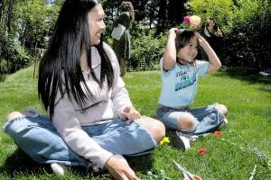 Juliet Shidler, 6, tries on a flower-adorned headband she made with her mother, Rachel Shidler of Port Angeles, during Saturdays Summertide celebration in Websters Woods sculpture park at the Port Angeles Fine Arts Center. The event, which marks the beginning of the summer season, featured food, music, crafts and other activities for youths and adults. (Keith Thorpe/Peninsula Daily News)