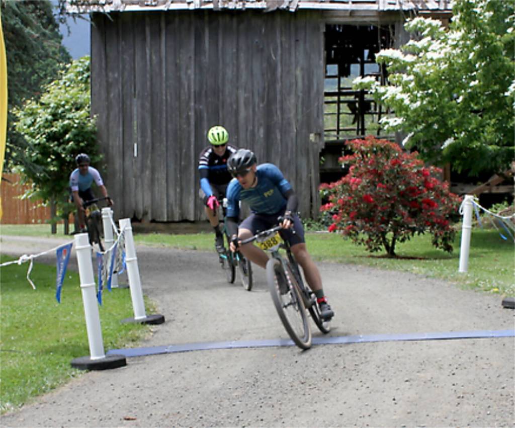 Tyler Klansnic of lake Forest Park wins the 80-mile Gravel Unravel race crossing the finish line at Worthington Park in Quilcene just two second ahead of Ben Schauland of Seattle.