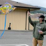 Randy Nobbs of Sequim attempts to get a kite to take flight on Wednesday at Carrie Blake Park in Sequim. A line of sheltering trees made it difficult to launch the kite until he received help from family members to get the aerial glider above the tree line and into the breeze. (Keith Thorpe/Peninsula Daily News)