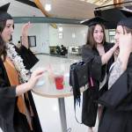 Peninsula College nursing students, from left, Emily Haddock of Lewiston, Idaho, Jordan Hegtvedt of Sequim and Chaela Cashman of Port Angeles adjust each others mortar boards in preparation for commencement ceremonies on Saturday on the colleges Port Angeles campus. A total of 328 students were expected to take part in two ceremonies with 530 students eligible for diplomas and certificates for the 2024-25 academic year. (Keith Thorpe/Peninsula Daily News)