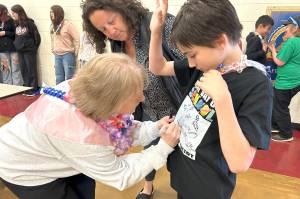 Reading Specialist Christine MacDougall Danielson signs fifth-grader Orion Schmits last day of school shirt with help from paraeducator Elizabeth Joers. (Matthew Nash/Olympic Peninsula News Group)