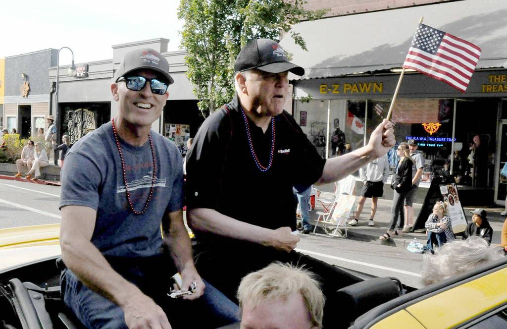 Black Ball Ferry Line co-owners Rian Anderson, vice president of terminal operations, left, and Ryan Burles, president and chief operating officer, ride through the streets as grand marshals of the Port Angeles Independence Day parade on Friday. (Keith Thorpe/Peninsula Daily News)