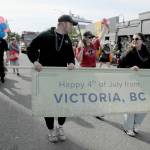 A contingent of visitors from Victoria march with the grand marshals parade entry celebrating the Black Ball Ferry Line and the longstanding cultural and economic ties forged by the Coho ferry. (Keith Thorpe/Peninsula Daily News)