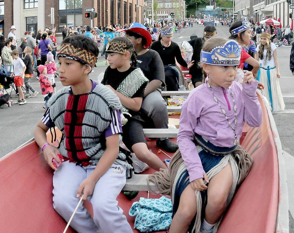 Children from the Lower Elwha Klallam Tribe ride in a canoe being trailered as the tribes July 4 parade entry. (Keith Thorpe/Peninsula Daily News)