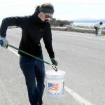 Emily Simmons of Port Angeles, a member of the Surfriders Foundation, collects fireworks debris from along Ediz Hook Road in Port Angeles on Saturday. Although fireworks have been banned in the city of Port Angeles, many people used them illegally, leaving behind trash and spent casings and tasking volunteers to pick up the remains. A group from 4PA performed similar cleanup duty on another portion of the hook. (Keith Thorpe/Peninsula Daily News)