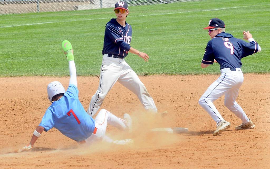KEITH THORPE/PENINSULA DAILY NEWS Kingstons Connor Oase slides into second after being forced out by Wilder Juniors Zach DeBray, right, after a short toss from shortshop Bryce DeLeon for the first leg of a double play on Saturday at Port Angeles Civic Field.