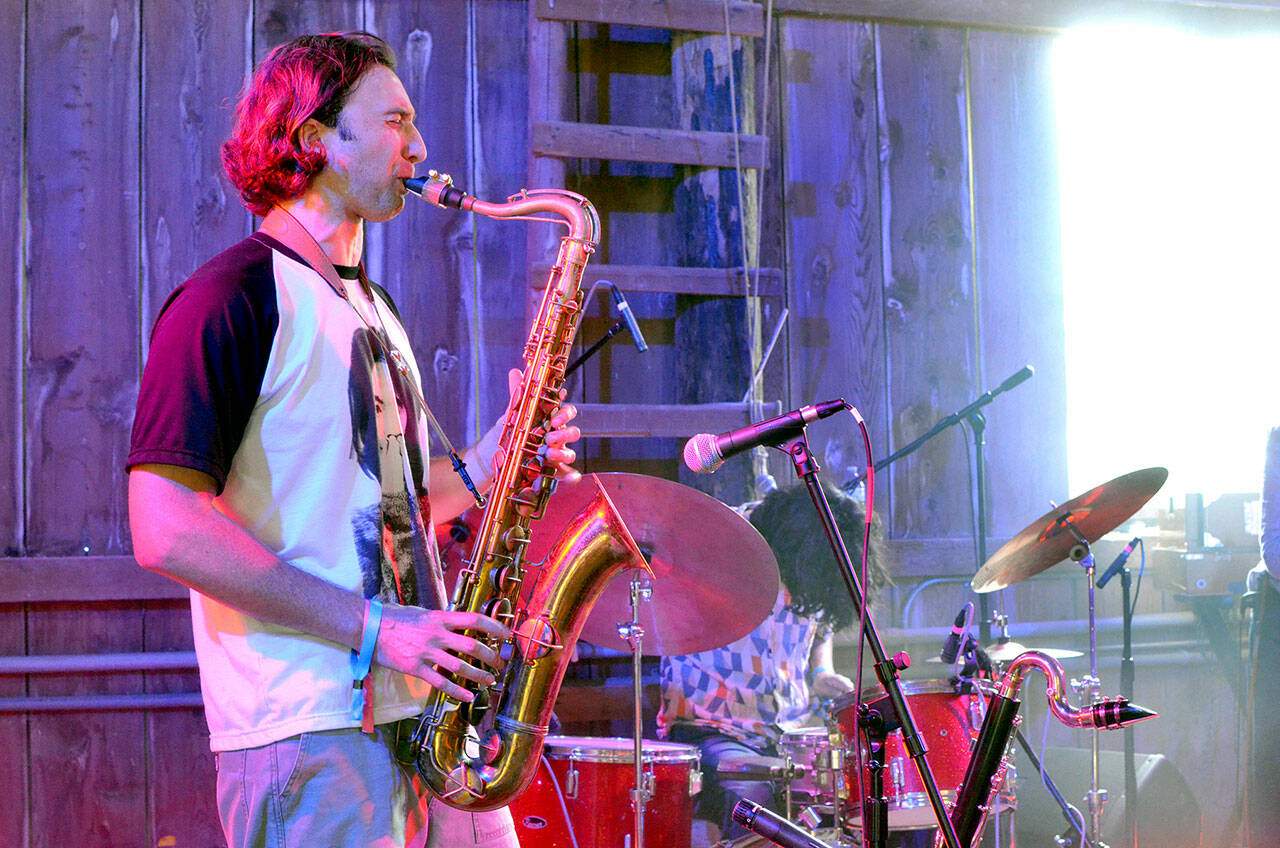 Levi Gillis, the saxophonist for The Sky Is A Suitcase, plays during a concert on July 5. (Elijah Sussman/Peninsula Daily News)