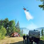 A helicopter joins the firefighting effort Tuesday afternoon at the Belgian Fire near Brinnon. (Brinnon Fire Department)