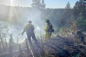 Firefighters from Clallam 2 Fire-Rescue oversee a brush fire Wednesday in the area of Baker Farm Road. (Clallam 2 Fire-Rescue)