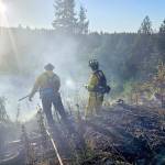 Firefighters from Clallam 2 Fire-Rescue oversee a brush fire Wednesday in the area of Baker Farm Road. (Clallam 2 Fire-Rescue)