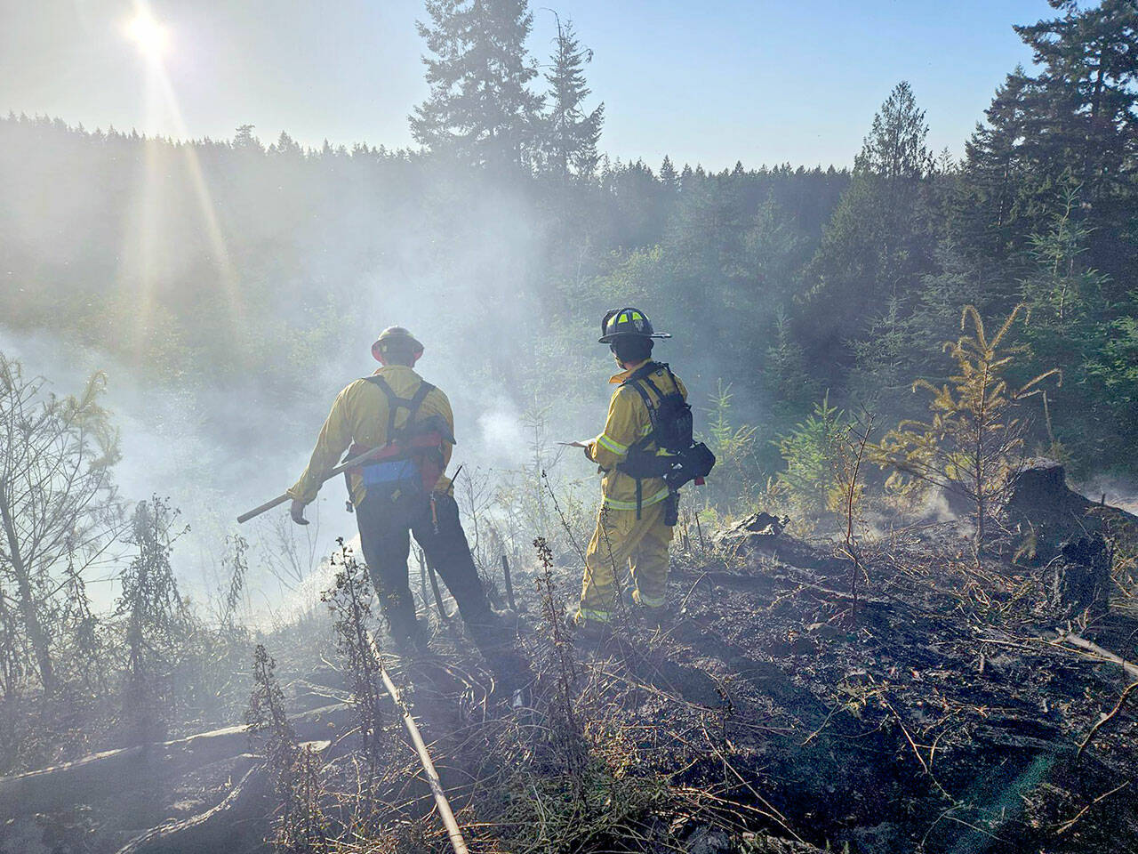 Firefighters from Clallam 2 Fire-Rescue oversee a brush fire Wednesday in the area of Baker Farm Road. (Clallam 2 Fire-Rescue)