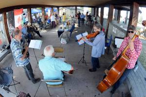 Members of the musical group Soupbones, from left, Ed Schmid of Port Angeles, Ron Munro of Sequim, Carly List of Port Angeles and Hugh Starks of Sequim, perform at a Good Trouble community gathering and picnic on Thursday at Erickson Playfield in Port Angeles. Organizers of the event, one of numerous gatherings across the United States, decided to forego conventional politics while commemorating the life of civil rights activist John Lewis. (Keith Thorpe/Peninsula Daily News)