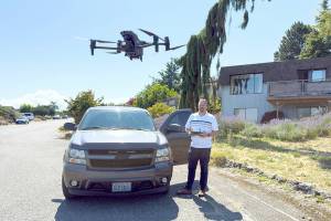 Det. Sgt. Jason Greenspane of the Port Townsend Police Department sets a drone in a hover mode after he brought it back from a test flight. Greenspane wanted to determine how far he could get a clear signal. On this flight, he flew the drone over the boat haven and all the way to Point Hudson Marina and back, a distance of about 2 1/2 miles. The drone is equipped with a camera that zooms, pans and swivels 360 degrees and can shoot still images as well as video. The police use the drone for search and rescue operations and other life-saving missions. (Steve Mullensky/for Peninsula Daily News)