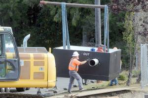 KEITH THORPE/PENINSULA DAILY NEWS
Workers maneuver a newly-delivered vault containing a water valve at the site of a valve replacement project on Thursday at the Jones Street Reservoir in Port Angeles.
