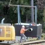 Workers maneuver a newly-delivered vault containing a water valve at the site of a valve replacement project on Thursday at the Jones Street Reservoir in Port Angeles. (KEITH THORPE/PENINSULA DAILY NEWS)