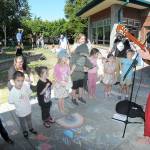 Youngsters gather on the lawn of the Port Angeles Public Library to listen to childrens entertainer Eli Rosenblatt of Seattle as part of the Port Angeles Parks and Recreation Departments citywide Day of Play. The Saturday event featured a variety of activities for children and their parents at venues across the city. (Keith Thorpe/Peninsula Daily News)