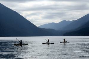 A trio of paddeboarders make their way across the waters of Lake Crescent off of Barnes Point on Sunday in Olympic National Park. Calm winds made for an ideal day for watercraft on the popular lake west of Port Angeles. (Keith Thorpe/Peninsula Daily News)