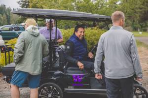 Former University of Washington quarterback Sonny Sixkiller, in cart, hosted his 14th annual celebrity golf tournament at Cedars at Dungeness this weekend. (Lexie Winters)