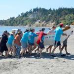 The Tana Stobs canoe, a family memorial canoe with members from the Port Gamble and Suquamish tribes, arrived first to the beach at Fort Worden on Tuesday. The canoe, in its 25th year, honors the memory of paddler Nic Armstrongs brother Santana Ives. Their trip from Port Gamble took 4 1/2 hours. (Elijah Sussman/Peninsula Daily News)