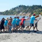 The Tana Stobs canoe, a family memorial canoe with members from the Port Gamble and Suquamish tribes, arrived first to the beach at Fort Worden on Tuesday. The canoe, in its 25th year, honors the memory of paddler Nic Armstrongs brother Santana Ives. Their trip from Port Gamble took 4 1/2 hours. (Elijah Sussman/Peninsula Daily News)