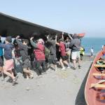 A Port Gamble SKlallam tribal canoe is pulled from the water on Thursday on territory owned by their relatives, the Lower Elwha Klallam. (Keith Thorpe/Peninsula Daily News)
