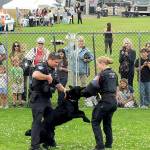 Port Angeles Police officers Kenneth McKnight, left, and Lilliana Emery give a canine demonstration with Freddy, a trained police dog, during Tuesdays National Night Out at Port Angeles Civic Field. The nationwide event brought law enforcement agencies, watch groups and civic organizations together for an evening of community building, featuring informational displays, childrens activities and a large-screen movie presentation. (Keith Thorpe/Peninsula Daily News)
