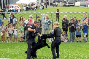 Port Angeles Police officers Kenneth McKnight, left, and Lilliana Emery give a canine demonstration with Freddy, a trained police dog, during Tuesdays National Night Out at Port Angeles Civic Field. The nationwide event brought law enforcement agencies, watch groups and civic organizations together for an evening of community building, featuring informational displays, childrens activities and a large-screen movie presentation. (Keith Thorpe/Peninsula Daily News)