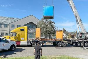 Workers with A&R Solar, Millican Crane Service and Trane Technologies guide a battery energy storage system into place Friday at the Port Angeles Senior Center. The city received a $450,000 grant from the state Department of Commerce to install the battery system and a solar array  solar cells wired together to create energy  to provide heating and cooling in case of a power outage. (Paula Hunt/Peninsula Daily News)