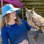 Abby Dugle of Sebastopol, Calif., holds Marvin, a Eurasian eagle owl, during a Raptor Experience at the Jefferson County Fair on Friday. Dugle paid $50 for the experience of holding the raptor that is used as a stand-in for great horned owls due to their resemblance. Dugle described the experience as wonderful and exciting. The Raptor Experience will be showing other raptors today and Sunday during the fair. (Steve Mullensky/for Peninsula Daily News)