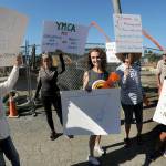Former Olympic Peninsula YMCA employee Mikki Hughes, center, stands on Wednesday in front of the Port Angeles YMCA with friends and co-workers who protested Hughes dismissal from her longtime duties as fitness instructor and fitness coordinator. (Keith Thorpe/Peninsula Daily News)