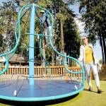 Carlyn Beebe of Forks pushes a merry-go-round toy as her son, Lane, 6, takes a ride on Tuesday at the Dream Playground at Erickson Playfield in Port Angeles. The pair took time out from errands for a visit to the popular park. (Keith Thorpe/Peninsula Daily News)